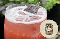 a glass of a drink with a mint leaf in it