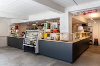 the interior of a coffee shop with a counter and a refrigerator